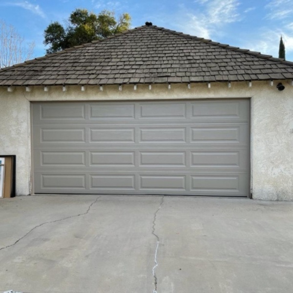Technician completing a small garage door repair visit at a Winnetka tract home