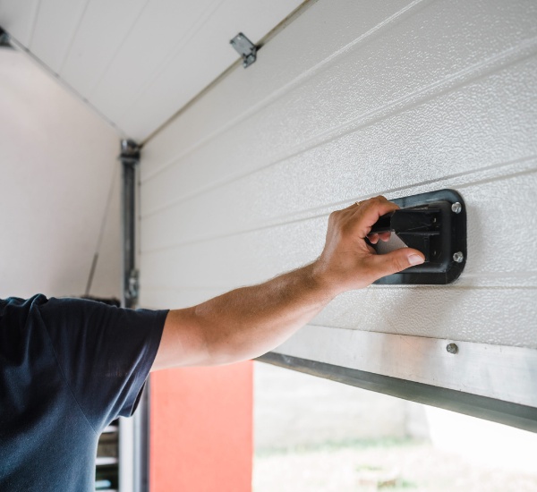Technician servicing a garage door opener motor on a service visit in Los Angeles