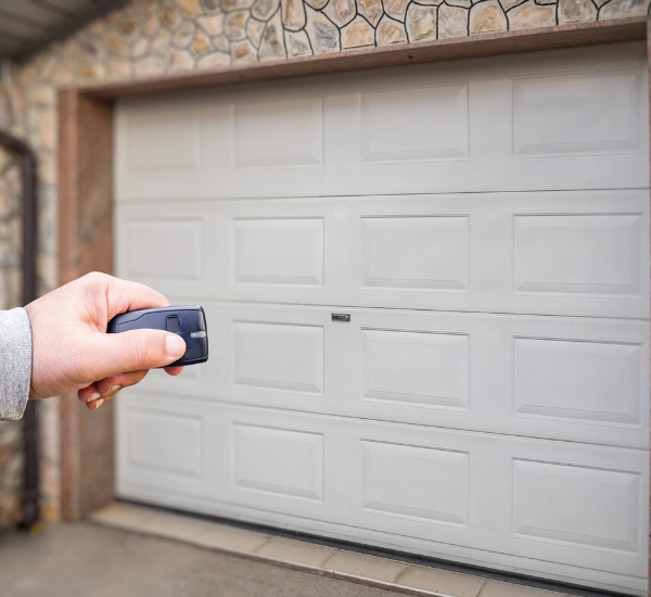 Replacement garage door safety sensor being wired and tested by a technician