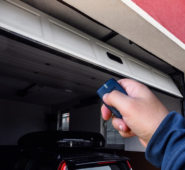 Technician realigning photo-eye safety sensors on a garage door that won't open