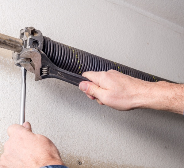 Technician replacing a broken garage door spring in Los Angeles