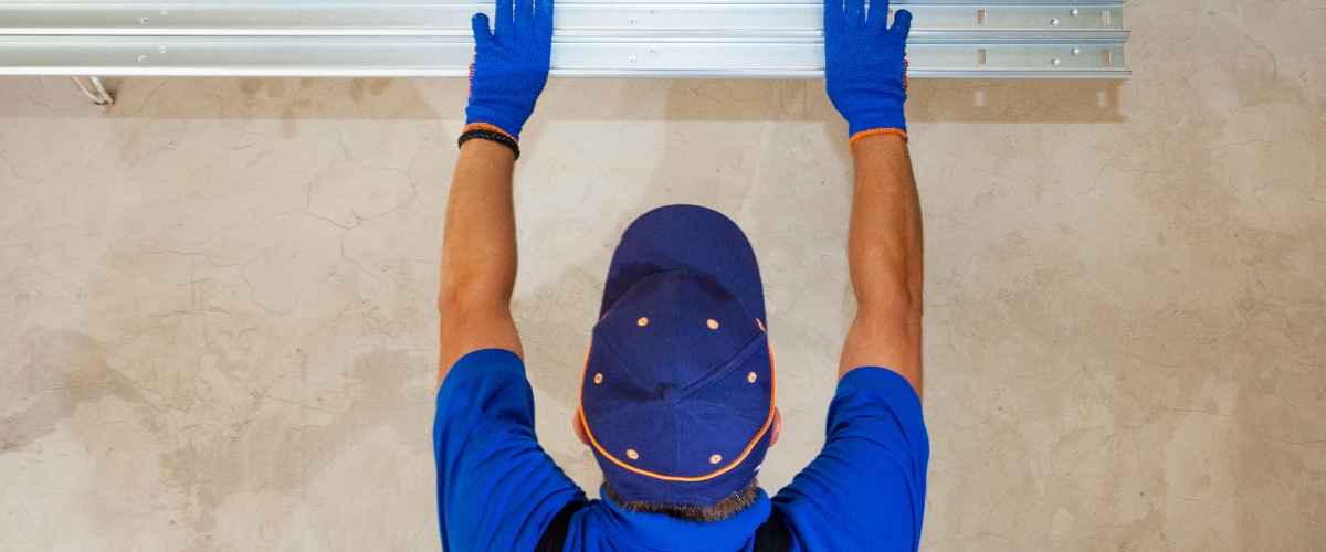 Broken garage door cable being repaired in Los Angeles home.