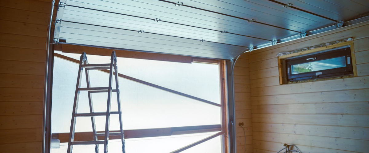 A professional technician installing a new garage door in a modern home in Los Angeles.