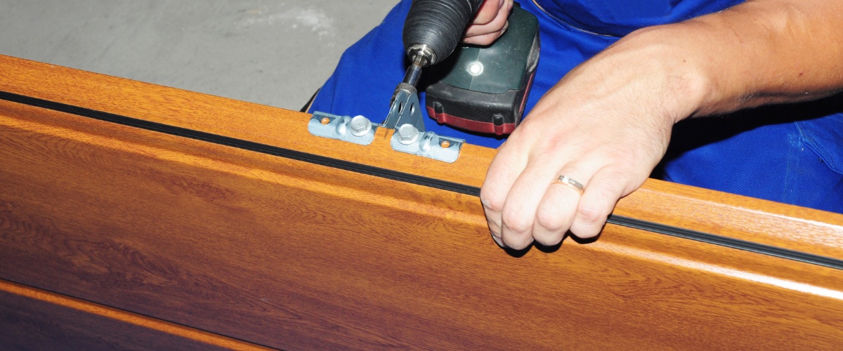 A technician adjusting the tension of a garage door spring in Los Angeles.