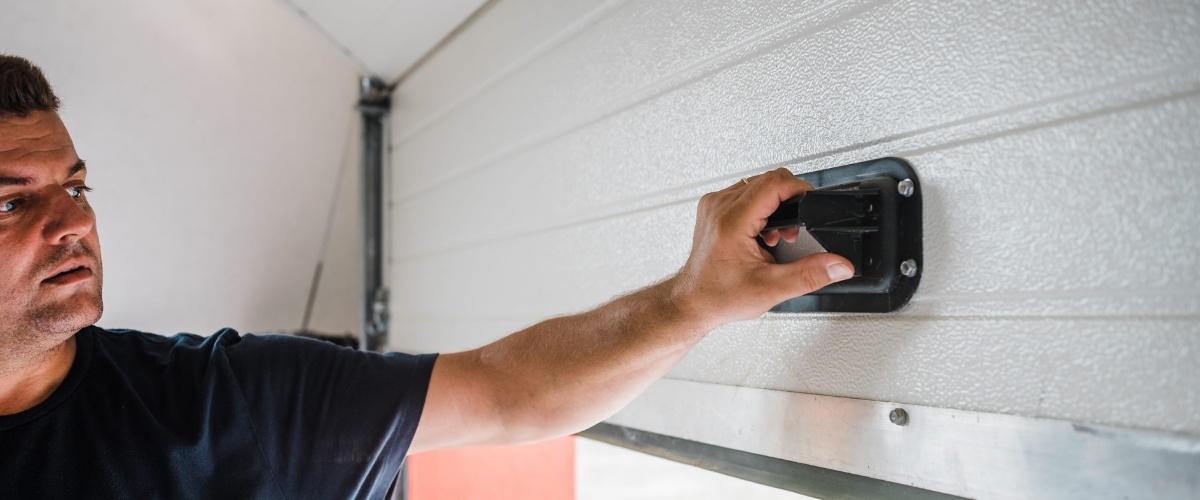 Experienced technician repairing garage door rollers in Los Angeles.